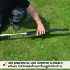 A person is holding a hedge trimmer with a protective cover on the blade, on a grassy lawn. Produktbild-Vorschau
