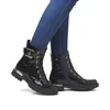 A person wearing black boots and blue jeans. Produktbild-Vorschau