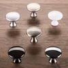 A collection of cabinet knobs on a wooden surface. Produktbild-Vorschau