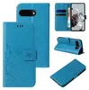 Collage of images showing a blue flip phone case with floral and butterfly embossed design, displaying different angles and usage. Produktbild-Vorschau