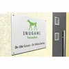 A sign for a veterinary clinic mounted on a textured wall next to a dark gray door with two small windows. Podgląd zdjęcia produktu