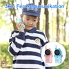 A young boy holding a walkie-talkie, with two toy walkie-talkies in the foreground. Produktbild-Vorschau