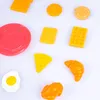A collection of toy food items arranged on a white background. Produktbild-Vorschau