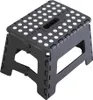 A black folding step stool with white dots on the top surface, shown from a slight angle against a white background. Produktbild-Vorschau