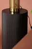 A close-up shot of a black cylindrical table with a gold lamp on top. Anteprima dell’immagine prodotto
