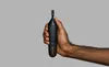 A hand holding a black hair trimmer against a plain gray background. Produktbild-Vorschau