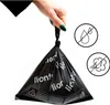 A hand holding a black bag filled with cat litter bags. Anteprima dell’immagine prodotto