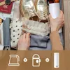 A person is packing a suitcase with clothes, shoes, and a travel kettle. Below is a graphic showing a kettle, a plus sign, a travel mug, an equals sign, and a travel kettle. Produktbild-Vorschau