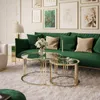 A living room scene with a green sofa, coffee tables, and artwork on the wall. Produktbild-Vorschau