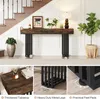 A console table is placed in a hallway next to a staircase, decorated with plants and a lamp. Náhľad obrázku produktu