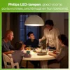 A family is gathered around a dining table, illuminated by a large pendant lamp. Produktbild-Vorschau