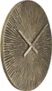 A close-up, angled view of a round wall clock with a textured, sunburst-like face and metallic hands. Náhľad obrázku produktu