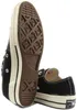 A pair of black Converse Chuck 70 low-top sneakers shown from a low angle, with one shoe's sole prominently displayed. Anteprima dell’immagine prodotto