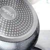 A close-up view of the bottom of a black speckled frying pan with a textured surface and a silver logo. Produktbild-Vorschau