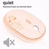 A close-up, angled view of a beige wireless computer mouse with gold trim and decorative heart and "love" graphics. Text overlays "quiet" and "Keyboard keys are almost silent" are present, along with a "mute" icon in the bottom left corner. Podgląd zdjęcia produktu