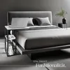 A modern bedroom with a bed and a laptop on a side table. Produktbild-Vorschau