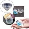 A collage of images showing various resin molds in the shape of diamonds, some filled with blue resin and glitter, and a hand holding one of the finished diamond shapes. Produktbild-Vorschau