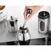 A hand is adding coffee grounds to a moka pot. Voir les images du produit
