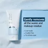 A white tube of facial cleanser is placed on a blue background with foam elements, next to text describing its benefits. Anteprima dell’immagine prodotto