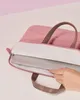 A hand is placing a laptop into a pink laptop bag. Produktbild-Vorschau