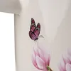 A close-up of a pink magnolia flower with a butterfly on it, on a light-colored background. Produktbild-Vorschau