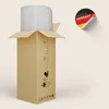 A cardboard box with a product wrapped in plastic inside, with an instruction diagram on the side and a 'Made in Germany' sticker. Produktbild-Vorschau