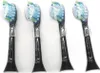 Four black toothbrush heads with blue and green bristles are arranged in a row against a white background. Produktbild-Vorschau