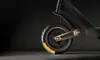 A close-up view of the front wheel and suspension of an electric scooter. Produktbild-Vorschau