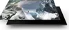 A person stands on a snowy ledge overlooking a glacial landscape, with a television screen displaying the scene overlaid on a black stand. Produktbild-Vorschau