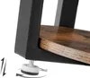 A close-up view of the bottom corner of a table, showing the adjustable foot and the connection between the metal frame and the wooden shelf. Podgląd zdjęcia produktu