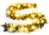 A green Christmas garland with warm white LED lights and pinecones, arranged in a curve on a white background. Produktbild-Vorschau