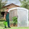 A man is standing in front of a greenhouse, holding a hose reel. Voir les images du produit