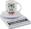 A white digital kitchen scale with a mug on top. Voir les images du produit