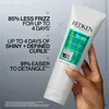 A hand holding a bottle of Redken hair product against a gray background with marketing text. Náhled obrázku produktu