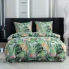 A neatly made bed with a tropical leaf-patterned duvet cover and pillowcases. Náhled obrázku produktu