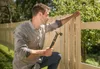 A man is building a wooden fence outdoors. Anteprima dell’immagine prodotto