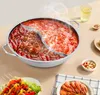 A split hot pot filled with spicy broth and chili peppers, along with skewers of vegetables and shrimp, is presented on a table. Podgląd zdjęcia produktu