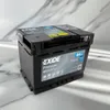A black EXIDE Premium EA 640 car battery is shown on a reflective, marbled surface with a blurred background. Produktbild-Vorschau