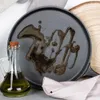 A close-up shot of a cast iron crepe pan with oil drizzled on it, next to a glass bottle of olive oil. Voir les images du produit