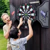 An older man and a younger boy are playing darts outdoors. Náhľad obrázku produktu