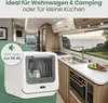 A compact dishwasher is shown inside a recreational vehicle (RV) kitchen, with a scenic view of the ocean and greenery through the window. Produktbild-Vorschau