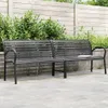 A dark metal and WPC garden bench is shown outdoors on a paved patio, with a wooden fence and greenery in the background. Produktbild-Vorschau