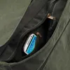 A close-up view of a green canvas bag with a smartphone inside a zippered pocket. Anteprima dell’immagine prodotto