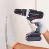A person wearing work gloves is holding a cordless drill and appears to be drilling into a wall. Produktbild-Vorschau