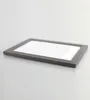 A framed picture lying flat on a light gray surface. Produktbild-Vorschau