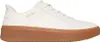 A side view of a white Skechers slip-on sneaker with a brown sole. Voir les images du produit