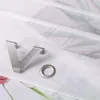 A close-up view of a metal curtain hook and a metal eyelet, placed on a white fabric with a floral pattern. Produktbild-Vorschau