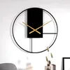 A modern, minimalist wall clock with gold hands against a white wall. Produktbild-Vorschau
