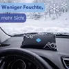 A car's dashboard with a dehumidifier bag on it, with a snowy landscape visible through the windshield. Produktbild-Vorschau