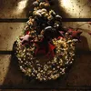 A Christmas wreath decorated with pine cones, red stars, and warm white LED lights, hanging on a wooden wall. Náhled obrázku produktu